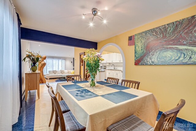 dining space featuring light tile patterned floors and sink