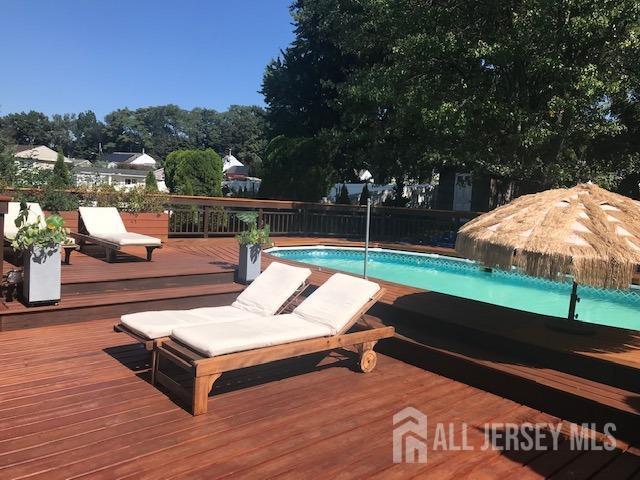 view of swimming pool featuring a wooden deck and pool water feature