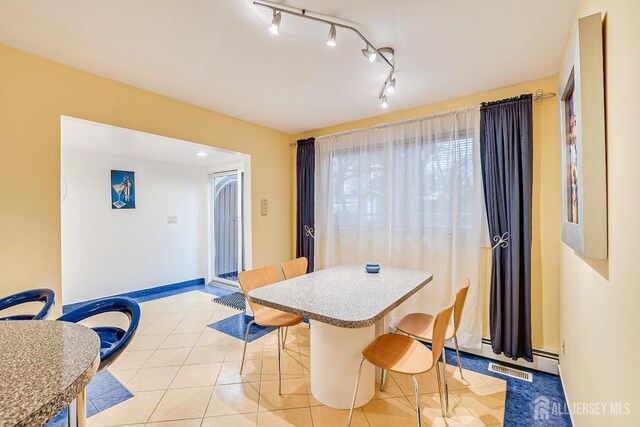 dining space featuring baseboard heating and light tile patterned floors