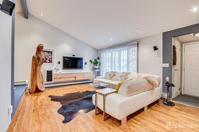 living room with a baseboard heating unit, light hardwood / wood-style flooring, and lofted ceiling