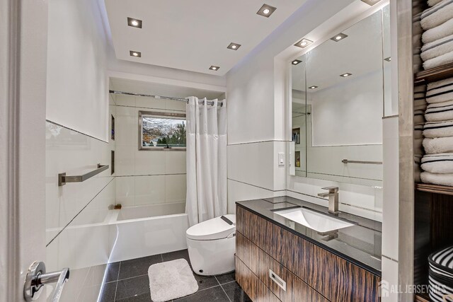 full bathroom featuring shower / bathtub combination with curtain, tile patterned flooring, toilet, vanity, and tile walls