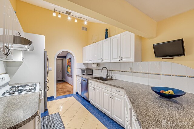 kitchen featuring stainless steel appliances, extractor fan, sink, white cabinetry, and light tile patterned flooring