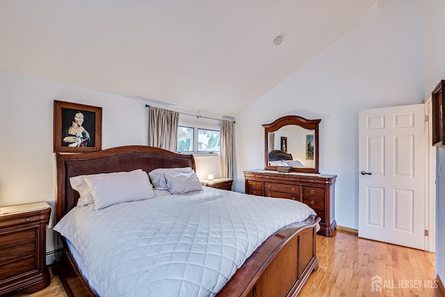 bedroom with vaulted ceiling and light wood-type flooring