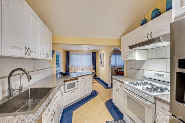 kitchen with decorative backsplash, sink, white cabinets, and white appliances