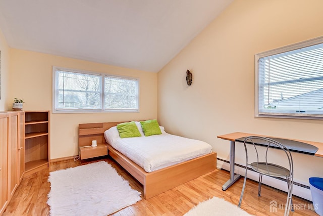 bedroom with light hardwood / wood-style flooring, lofted ceiling, and a baseboard heating unit