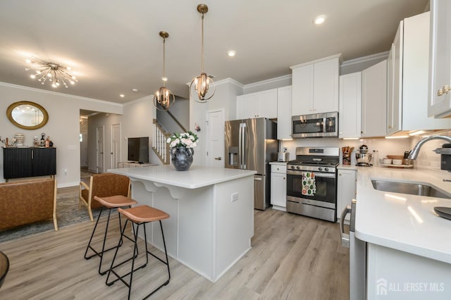 45 Athens Way, Aberdeen, NJ 07721 - kitchen featuring appliances with stainless steel finishes, open floor plan, ornamental molding, a breakfast bar, and a center island