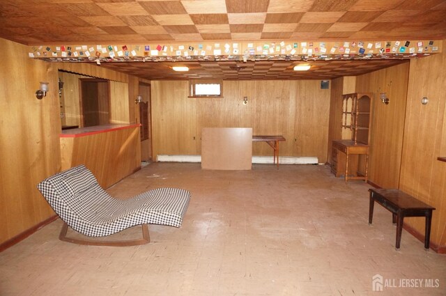 finished basement featuring wooden walls and tile patterned floors