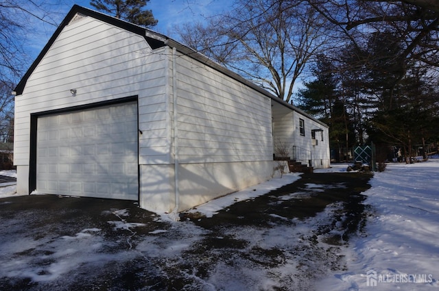 view of snow covered exterior with a detached garage