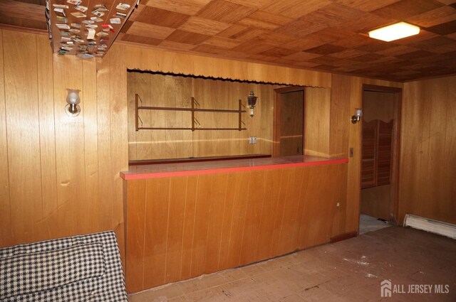 bar with wood walls, wooden ceiling, and a baseboard radiator