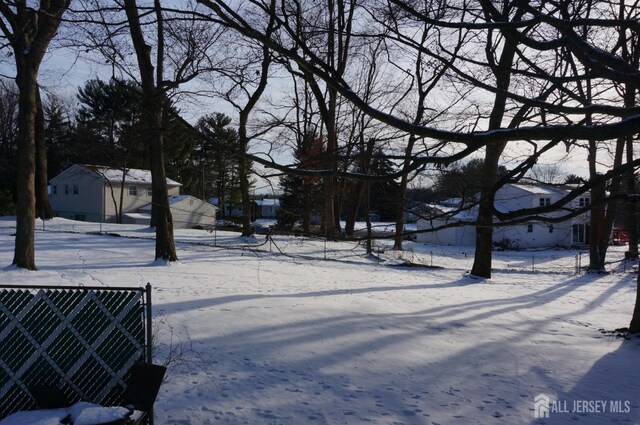 yard covered in snow featuring fence