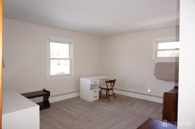 office area featuring light carpet, a baseboard radiator, and a healthy amount of sunlight