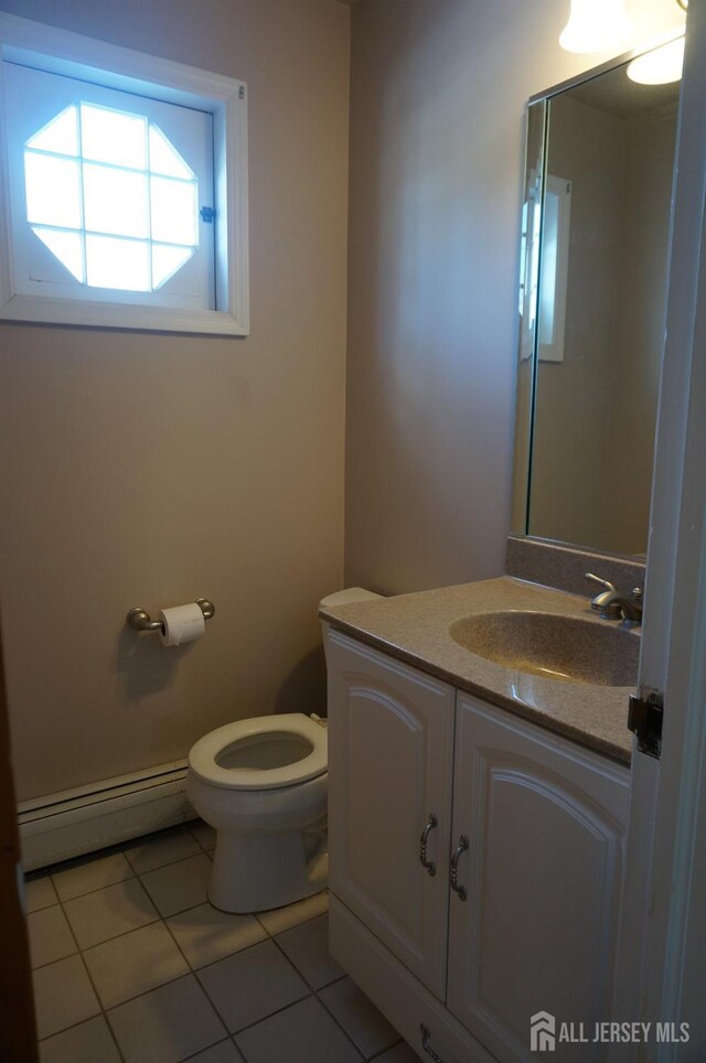 bathroom featuring a baseboard radiator, vanity, toilet, and tile patterned floors