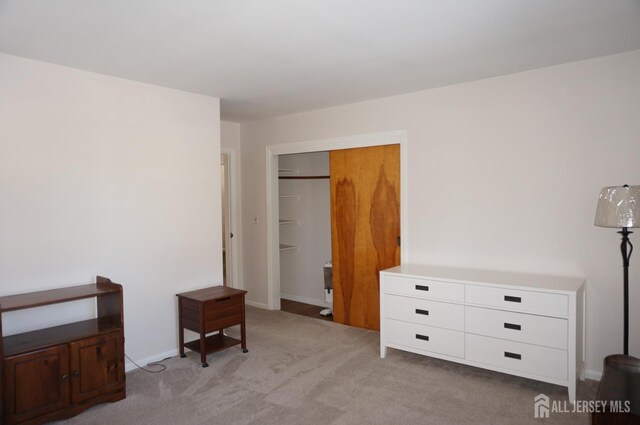 bedroom with a closet and light carpet