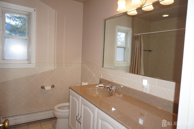 bathroom with tile walls, toilet, a baseboard heating unit, vanity, and tile patterned floors