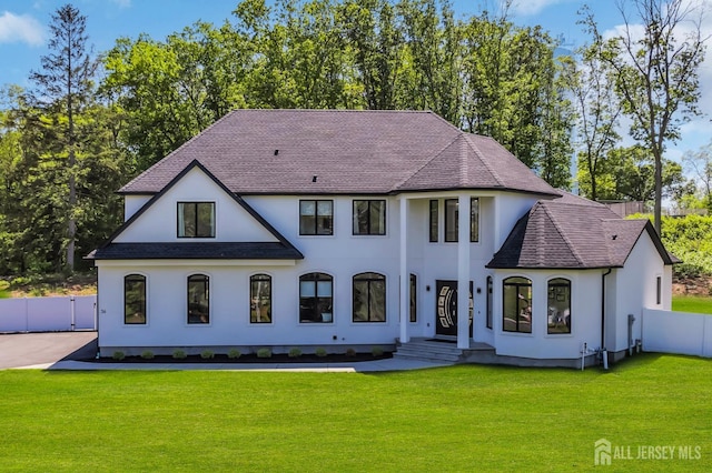 36 School Rd E, Marlboro, NJ 07746 - back of property featuring roof with shingles, stucco siding, and view of wooded area