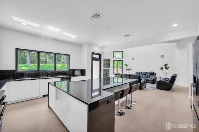 36 School Rd E, Marlboro, NJ 07746 - kitchen featuring dark countertops, modern cabinets, white cabinets, recessed lighting, and a kitchen island