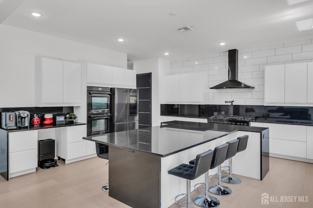 36 School Rd E, Marlboro, NJ 07746 - kitchen with wall chimney exhaust hood, dark countertops, modern cabinets, a kitchen bar, and white cabinetry