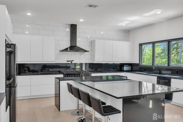 36 School Rd E, Marlboro, NJ 07746 - kitchen featuring wall chimney range hood, modern cabinets, a breakfast bar area, tasteful backsplash, and white cabinets