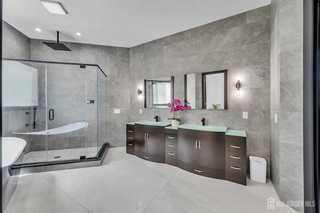 36 School Rd E, Marlboro, NJ 07746 - full bath featuring tile walls, double vanity, a stall shower, a freestanding tub, and tile patterned flooring