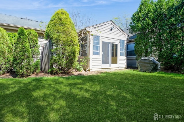 rear view of house with an outbuilding and a yard