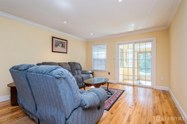 living area featuring baseboards, ornamental molding, light wood finished floors, and plenty of natural light