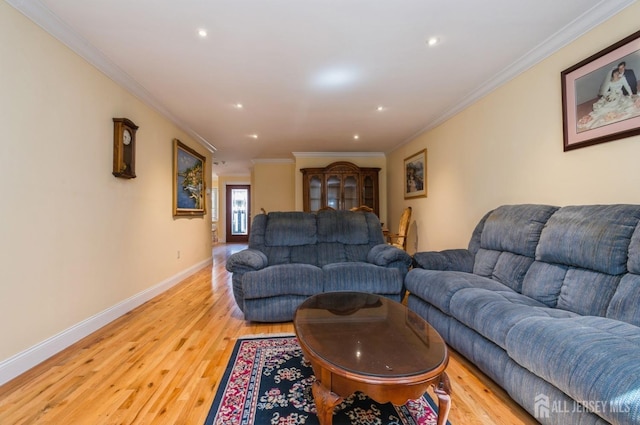 living room featuring crown molding, baseboards, and light wood-style flooring
