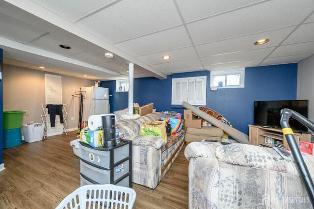 living room featuring hardwood / wood-style floors and a drop ceiling