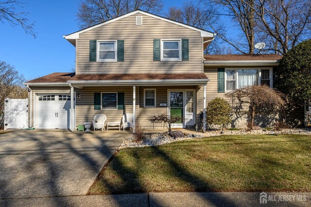 tri-level home featuring a garage, a front lawn, and covered porch