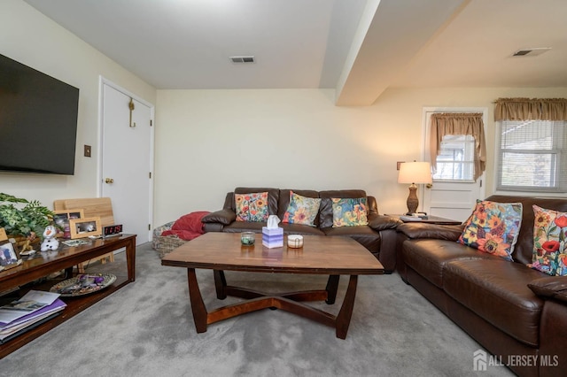 carpeted living room featuring beamed ceiling