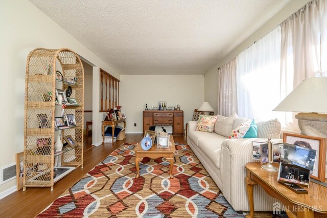 living room featuring a textured ceiling and hardwood / wood-style floors