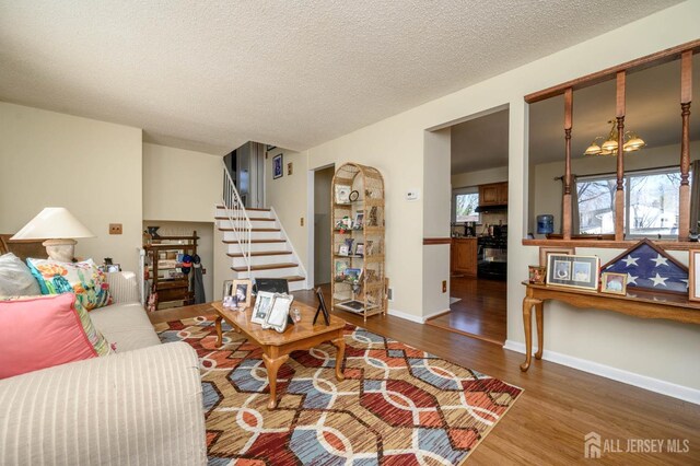 living room featuring wood-type flooring and a textured ceiling