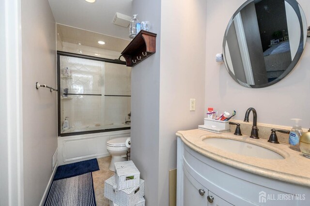 full bathroom featuring bath / shower combo with glass door, toilet, vanity, and tile patterned flooring