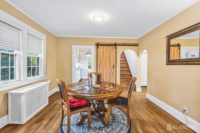 425 Grove Ave, Metuchen, NJ 08840 - dining space featuring radiator, wood finished floors, a barn door, healthy amount of natural light, and crown molding