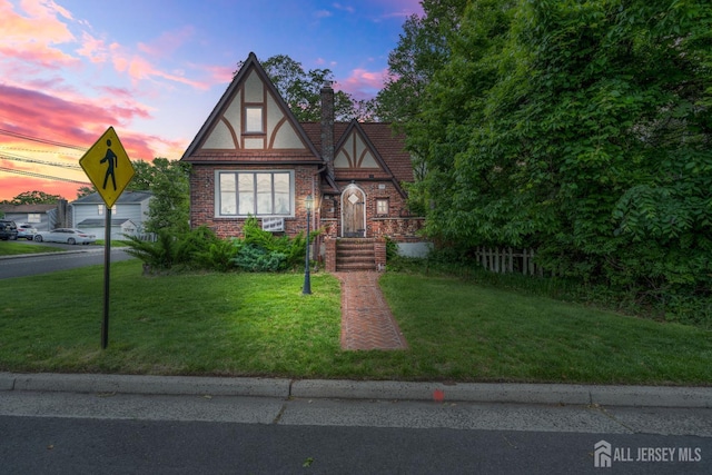 425 Grove Ave, Metuchen, NJ 08840 - tudor house with a front yard, a chimney, and brick siding