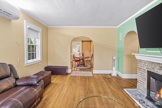 425 Grove Ave, Metuchen, NJ 08840 - living room with arched walkways, a wall unit AC, a fireplace, wood finished floors, and ornamental molding