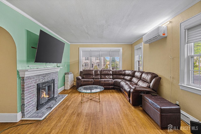 425 Grove Ave, Metuchen, NJ 08840 - living area with a wall mounted AC, wood finished floors, a fireplace, ornamental molding, and baseboards