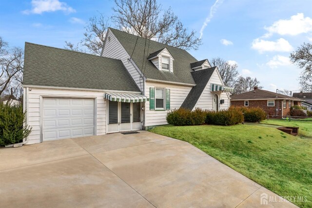 cape cod home featuring a garage and a front lawn