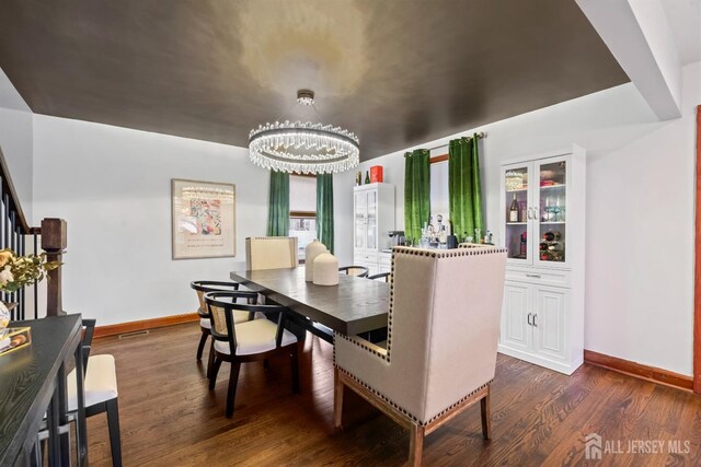 dining area with dark hardwood / wood-style flooring and a chandelier