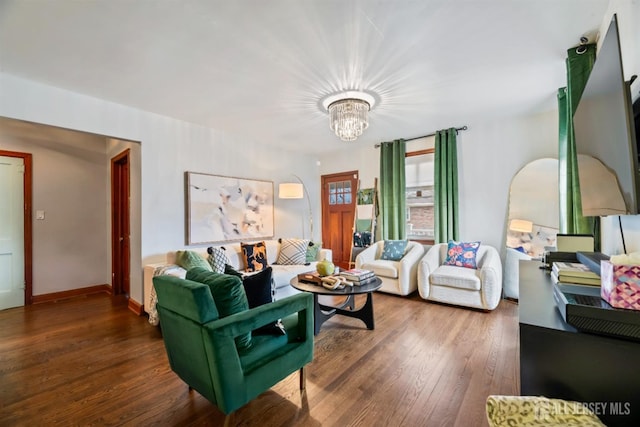 living room featuring a notable chandelier and dark wood-type flooring