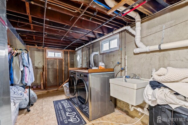 clothes washing area featuring sink and washing machine and clothes dryer