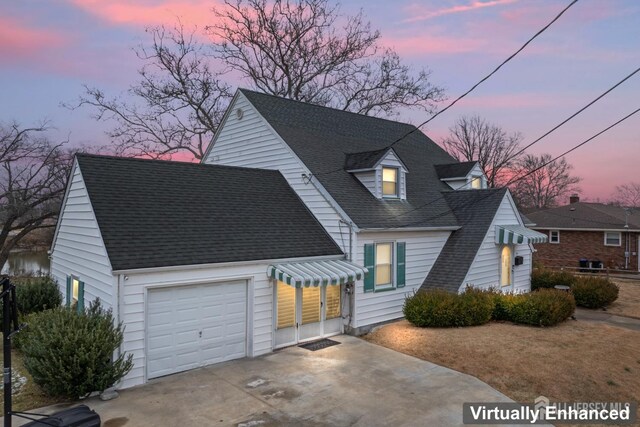 cape cod home featuring a garage