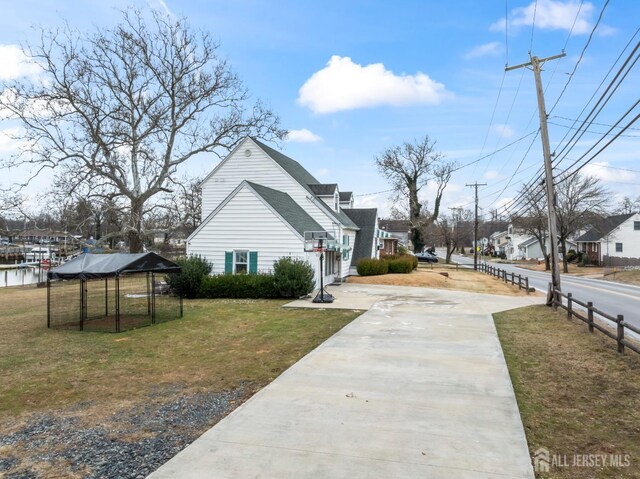 view of side of property featuring a water view and a lawn