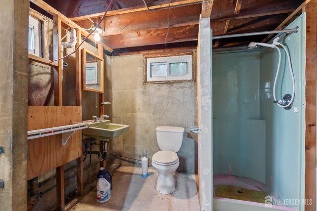 bathroom with toilet, walk in shower, and sink