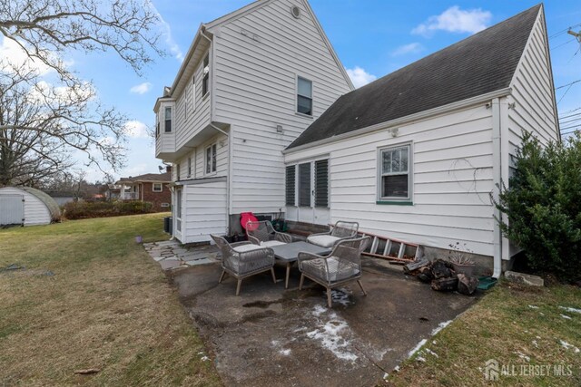 back of house featuring a patio area, a storage unit, and a yard