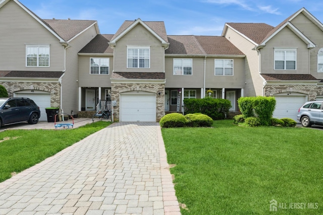 40 Dickerson Ln, Old Bridge, NJ 08857 - townhome / multi-family property with decorative driveway, a front yard, an attached garage, and stone siding