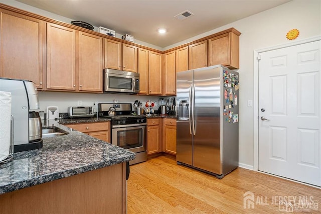 1515 NE Hudson Cir Unit 1515, Highland Park, NJ 08904 - kitchen with appliances with stainless steel finishes, light wood-type flooring, dark stone countertops, brown cabinets, and recessed lighting