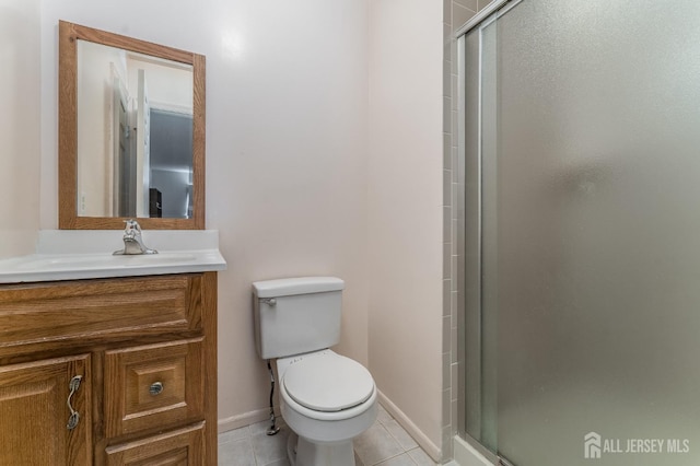 full bath with a stall shower, baseboards, toilet, tile patterned flooring, and vanity