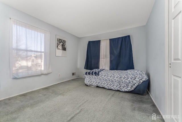 carpeted bedroom featuring visible vents and baseboards