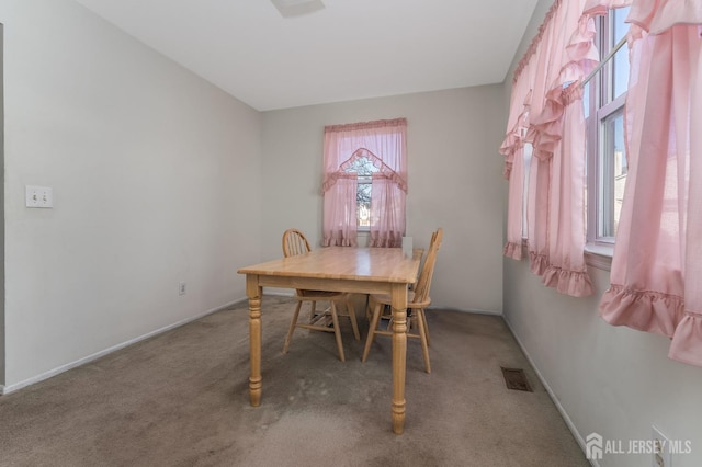 dining space with carpet flooring, visible vents, and baseboards