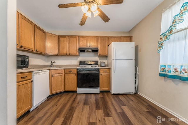 kitchen featuring dark wood-type flooring, white appliances, light countertops, and under cabinet range hood